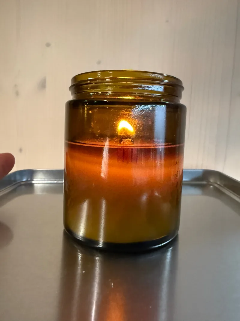 A lit TeraVida candle with a wooden wick